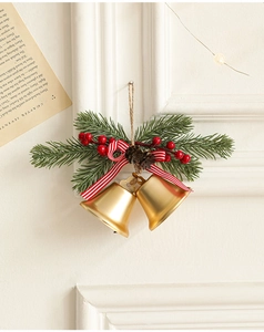 Detail von goldenen Weihnachtsklingeln mit Tannennadeln, roten Beeren und Bandschleife