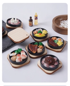 Detailed macro view of miniature resin food charms featuring steak and shrimp on wooden bases