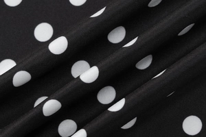 Gros plan sur la texture du tissu à pois noir et blanc avec détail de tissage