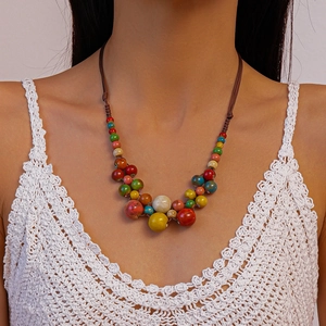 Gros plan d'un collier de perles rondes multicolores bohème avec cordon tressé