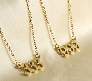 Detail of two 18k gold plated stainless steel necklaces featuring 999 number pendants