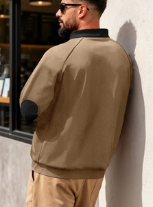 Détail d'une veste à col montant pour homme avec écussons noirs aux coudes et texture du tissu