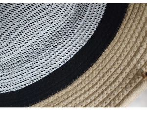 Detailed close-up of woven straw hat interior with black sweatband and white mesh lining