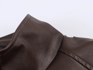 Detailed macro view of dark brown leather jacket collar with premium stitching craft
