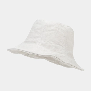 Dettaglio della trama del cappello da sole in cotone e lino bianco con pieghe naturali