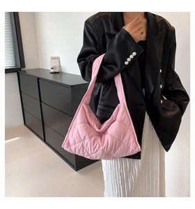 Detalle del bolso tote acolchado rosa con textura de rombos y asa ancha para el hombro