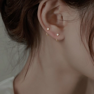 Minimalist gold ear hooks with clear zircon stones shown on a female model