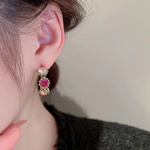 Detailed view of vintage gold stud earrings featuring three-color round crystal pendants