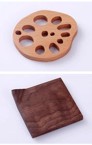 Close-up of lotus-inspired wooden coasters in light beech and dark walnut textures