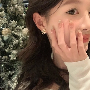 Gold-plated rocking horse stud earrings with sparkling zircons shown on a model