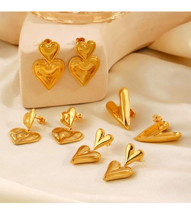 Macro shot of 18K gold plated double layered heart earrings on a silk background