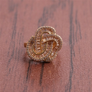 Bague cœur plaquée or 18K avec cristaux de zircon sur fond de bois sombre et chic