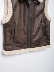 Close-up of brown faux leather vest with soft cream shearling lining and metal zipper