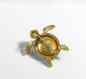 Detailed back view of a gold turtle brooch showing pin safety clasp and texture