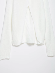 Detail of white chunky knit sweater featuring a unique overlapping cross back and curved hem