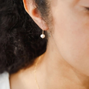 Minimalist gold-plated stainless steel drop earrings featuring natural freshwater pearls