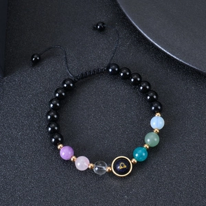 Detailed macro view of Libra zodiac sign bead with colorful crystals on braided bracelet
