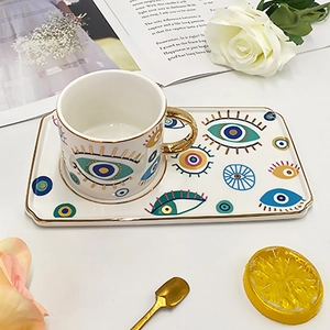 Ceramic Evil Eye coffee cup and tray set with gold rim and artistic floral background