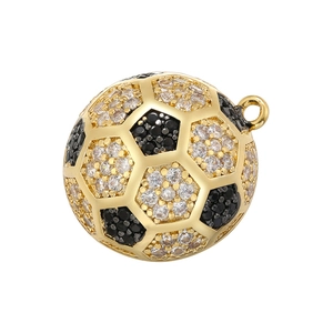 Detailed view of a gold football pendant set with black and white cubic zirconia stones