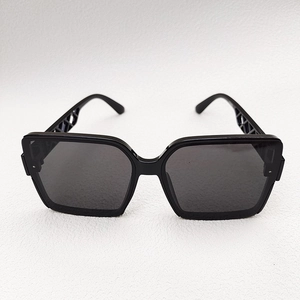 Detail of black oversized square sunglasses featuring unique hollow geometric temple design