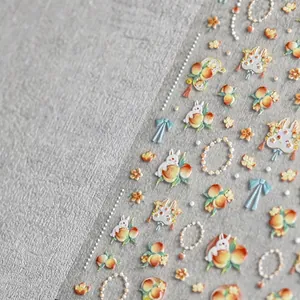 3D embossed nail art stickers featuring cute rabbits and peach motifs on matte background