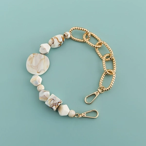 Detail of bohemian acrylic marble beads and gold metal chain for mobile phone cases