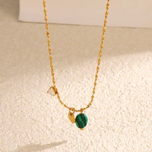 Collier doré en acier inoxydable avec pendentif malachite et zircon sur fond blanc