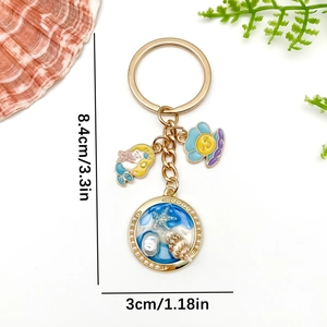 Marine keychain with blue resin starfish shell and mermaid charm in gold finish