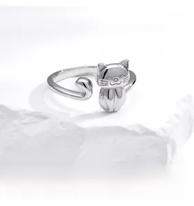 Close-up of adjustable 925 sterling silver cat ring on white textured stone background