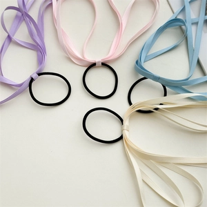 Close-up of elegant elastic hair ties with long flowing satin ribbons in pastel colors