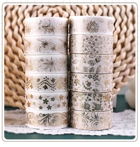 Macro view of 12 rolls vintage floral gold foil washi tape set on lace background