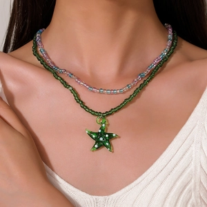 Dettaglio di una collana a doppio strato di perline con pendente a stella marina su modella