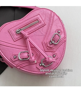 Détail du sac coeur rose avec fermetures éclair style motard et rivets argentés brillants