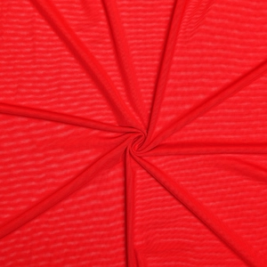 Close-up of lightweight red ribbed fabric texture with elegant radial pleats and draping