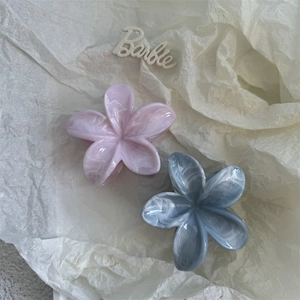 Detailed close-up of marble texture flower hair claws in lavender and slate blue colors