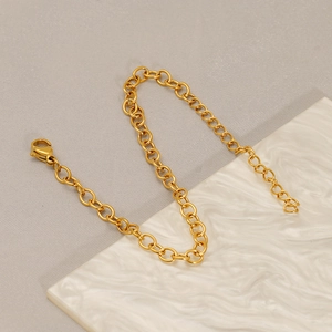 Minimalist gold stainless steel O-chain bracelet with lobster clasp on marble stone