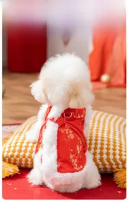 Close-up of red festive pet vest featuring gold plum blossoms and plush white fur trim