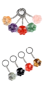 Macro shot of assorted colorful gemstone cat paw keychains with metallic ring attachments