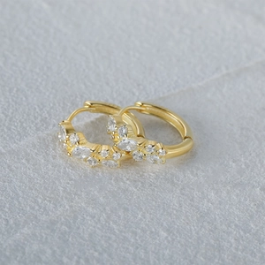Detail of gold-plated silver hoops featuring marquise and round-cut cubic zirconia
