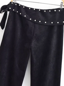 Detail view of black suede flared pants with silver rivet studs and lace-up waist design