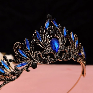 Macro view of baroque crown featuring a large blue teardrop gem and black crystals