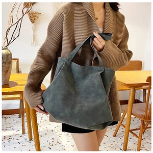 Detailed texture of a large dark grey-green tote bag with vintage stitching details