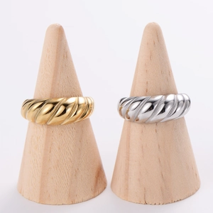 18K gold plated stainless steel tire tread rings in gold and silver colors on wood stands