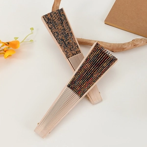 Artistic layout of vintage cork folding fans with yellow flowers and a wooden notebook