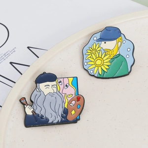 Artistic enamel pins featuring Van Gogh and Da Vinci portraits on a ceramic tray