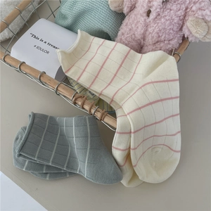 Cozy Morandi striped cotton socks in white-pink and grey-white inside a wire basket