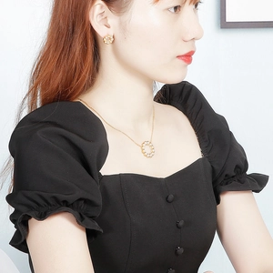 Elegante set di gioielli di perle dorate con orecchini e collana su una modella