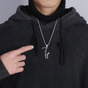 Silver saxophone pendant necklace with rope chain worn on a grey hoodie