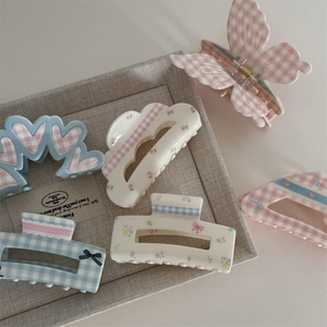 Detail view of floral and plaid hair claws with cute bow accents in pastel colors