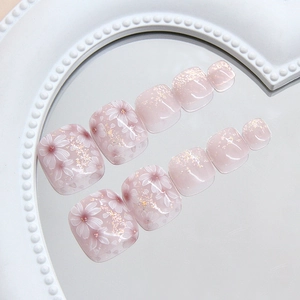 Pink shimmer press-on toenails with cherry blossom flower patterns and gold foil flakes